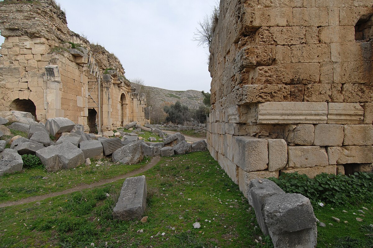 The Roman triumphal arch at Anavarza with the massive castle cliff behind