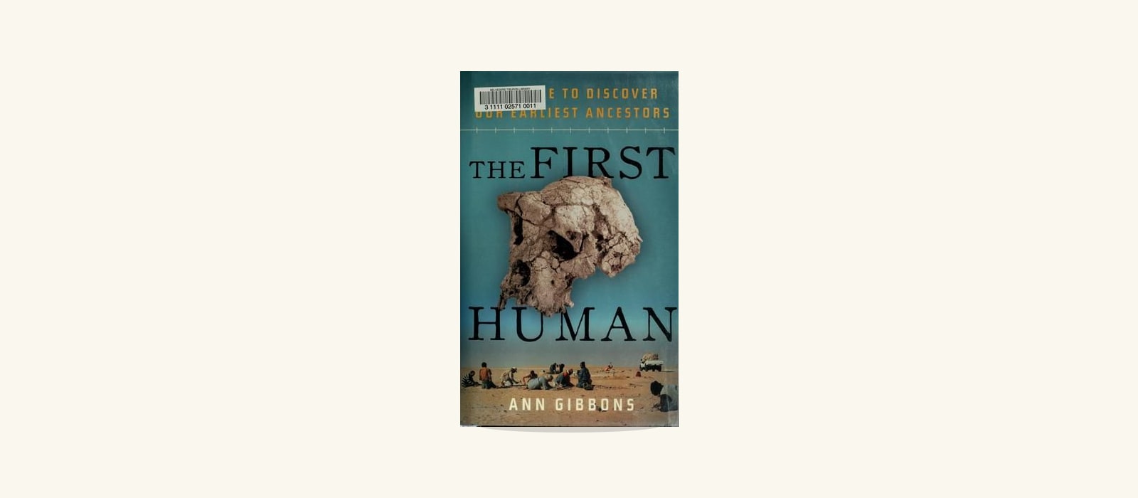Umschlag von "The First Human" von Ann Gibbons, der einen fossilen Hominidenschädel vor einer türkisfarbenen Wüstenausgrabungsfotografie zeigt